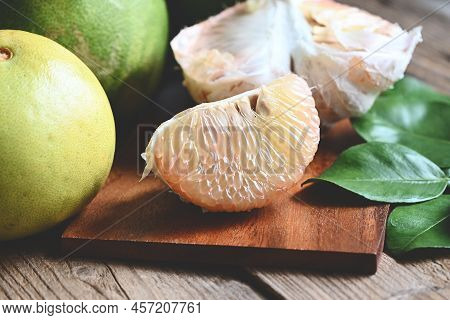Pomelo Fruit On Wooden Plate  Background, Fresh Green Pomelo Peeled And Leaf Frome Pomelo Tree , Pum