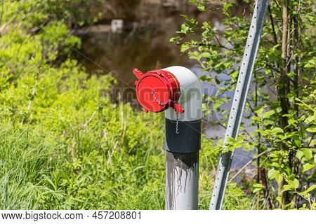 Close Up Selective Focus View Of A Dry Fire Hydrant With Blurry River, Natural Water Source In Backg