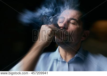 Portrait Of Hansome Man Smoking Cigar In A Lounge Bar With Motion Blur Effect