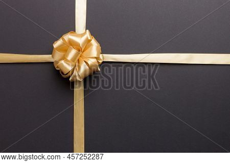 Top View Of Gold Ribbon Rolled And Yellowbow Isolated On Colored Background. Flat Lay With Copy Spac