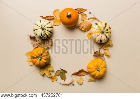 Autumn Composition Pumpkins With Fall Leaves Over Coloredbackground. Top View With Copy Space.