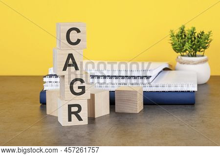 Cagr Word Written On Wooden Cubes With Copy Space, Yellow Background. Cagr - Compound Annual Growth 