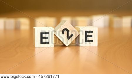 Word E2e Written On Wooden Cubes. Concept. Wooden Background. E2e - Short For End To End, Exchange T