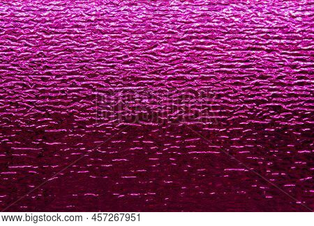 Shiny Purple Foil Background. Textured Surface Reflecting 
Pink Light From Grow Lamp