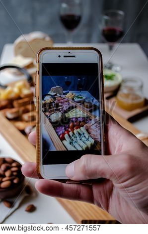 Taking Photograph Of Food Served On The Table With Your Smartphone. Delicious Charcuterie. Picada Ar