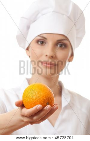 Smilende kvinde cook med orange, isoladed på hvid baggrund