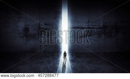 Businessman Looking Out Of Abstract Opening In Wall With Bright Daylight In Concrete Interior. Conce
