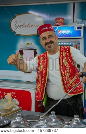 A Handsome Adult Man In Traditional Turkish Clothes Sells Turkish Ice Cream