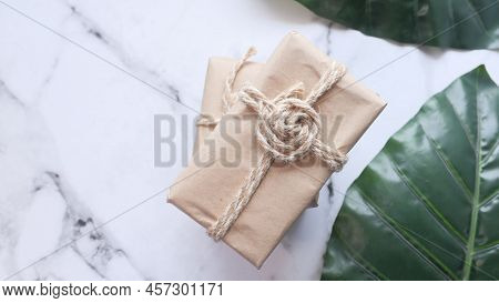 Gift Box On White Marble Stone With Green Fresh Leaf To Make Luxury Design. Stylish And Fashionable 