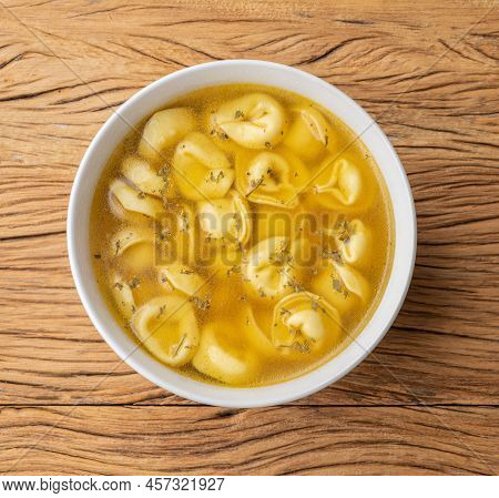 Cappelletti Or Tortellini Brodo Soup In A Bowl Over Wooden Table.