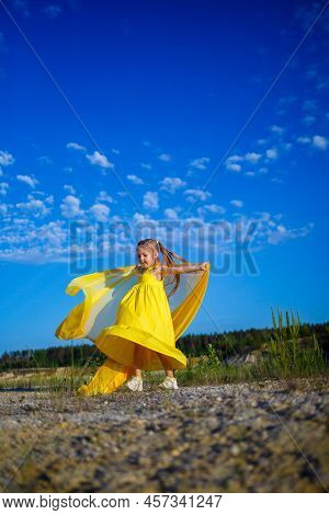 The Symbol Of Freedom Is A Ukrainian Girl Of 7 Years Old, Patriotically Dressed In A Yellow Dress Ag