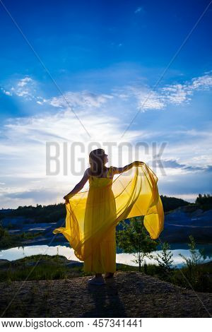 Happy Ukrainian Woman Running In Nature. In A Long Yellow Dress. Symbol Of Freedom Of Ukraine. Woman