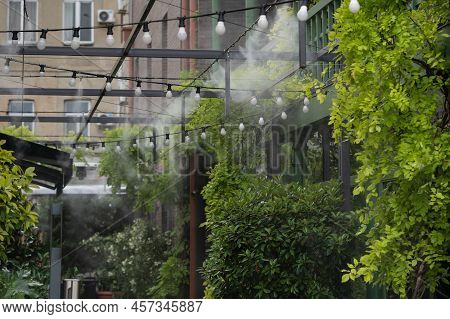 Fogging Outdoor Cool Misting System Working Hot Summer Day For Terrace In Cafe. Facility That Lowers