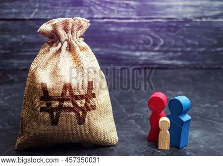 Family Figurines And South Korean Won Money Bag. Income Level, Budget. High Debt. Social Research, C