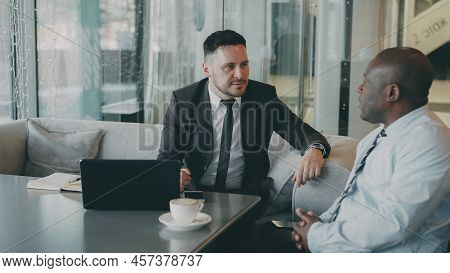 Two Ambitious Entrepreneurs Brainstorming Business Ideas Of Their Startup In Modern Cafe. African Am