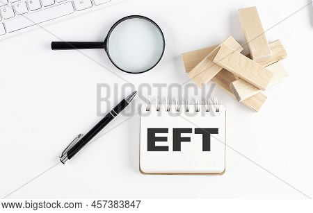 Eft Word Written On A Notebook With Block Magnifier And Pen , Business Concept.