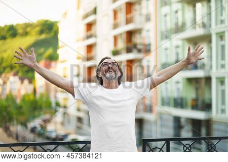Senior Man In Glasses Praising God Standing Outdoors With Hands Spread Wide Open Lifted In The Air W