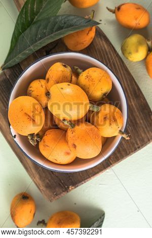 Ripe Medlar Fruit , Eriobotrya Japonica, And Green Medlar Leaves On Wooden Table. Top View