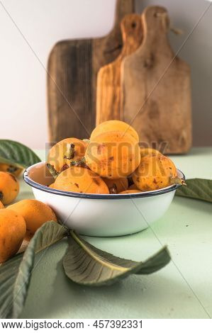 Ripe Medlar Fruit , Eriobotrya Japonica, And Green Medlar Leaves On Wooden Table. Top View