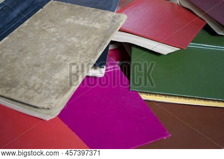 A Lot Of Books Are Piled Up. Color Books Are On Top Of Each Other. Open Books Are Paliturai Up. So M