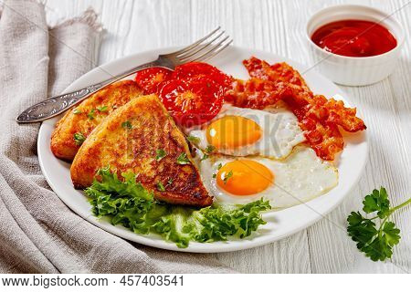 Fried Eggs, Rasher Or Bacon Slices, Potato Farls, Grilled Tomatoes And Fresh Lettuce On White Plate 