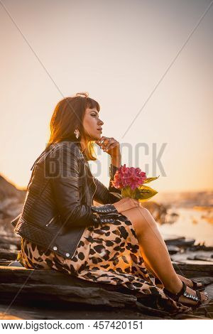 Summer Street Style On A Beach Next To Rocks Of A Young Brunette Caucasian Woman In A Leopard Dress 