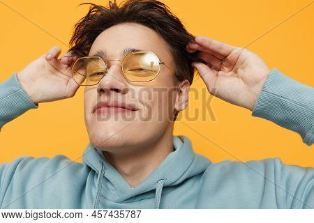 A Close Portrait Of A Funny Man Standing On An Orange Background In Bright Sunglasses Looking At The
