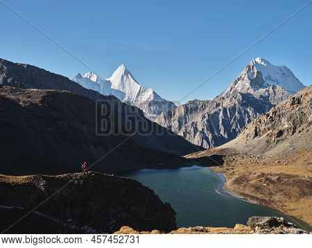Asian Hiker Looking At Mount Jampayang, Mount Chanadorje And Lake Boyongcuo At Sunrise In Yading Nat