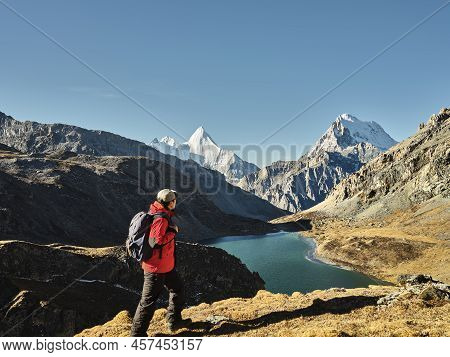 Asian Hiker Looking At Mount Jampayang, Mount Chanadorje And Lake Boyongcuo At Sunrise In Yading Nat