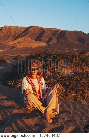 Woman Sitting On The Sand Ground And Meditate In Loto Yoga Position And Casual Clothes. Inner Balanc
