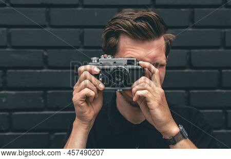 A Young Man Takes A Photo With A Vintage Film Camera.