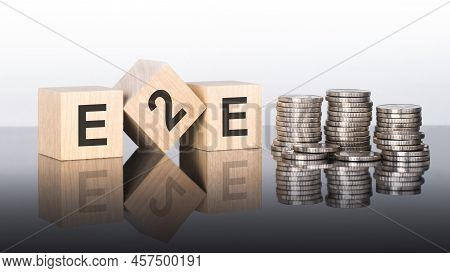 E2e - Text Is Made Up Of Letters On Wooden Cubes Lying On A Mirror Surface, Gray Background. Stacks 