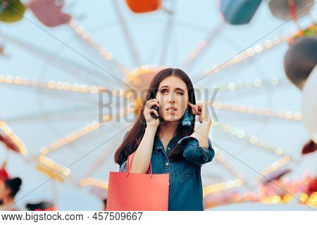 Woman Trying To Answer Her Phone In A Loud Amusement Park