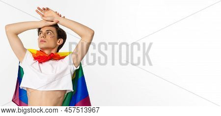 Waist-up Shot Of Sensual Androgynous Man Wearing Crop Top And Rainbow Pride Flag, Looking At Upper L
