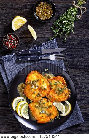 Chicken Piccata Of Parmesan Breaded Seared Chicken Breasts With Lemon Butter Caper Sauce On Black Pl