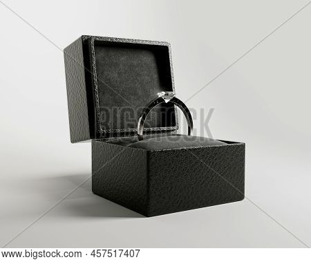 An Open Cube Shaped Black Ring Box With A Silver Engagement Ring And Large Cut Diamond On An Isolate