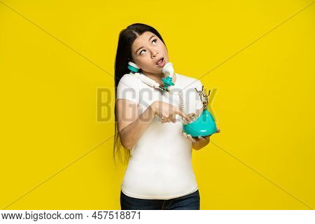 Funny Asian Woman Using Vintage, Retro Telephone In Hands Dreamingly Dialling Trying To Remember Pho