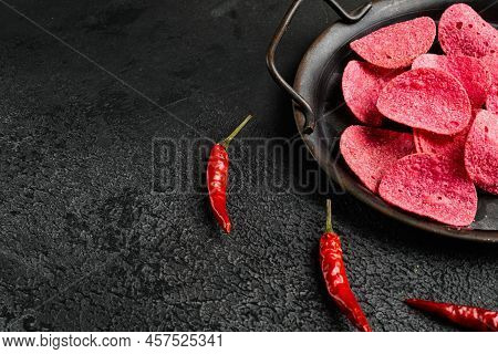 Adobadas Flavored  Red Potato Chips, On Black Dark Stone Table Background, With Copy Space For Text