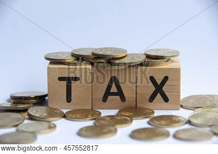 Tax Word On Wooden Block Surrounded With Gold Coins. Taxation Concept