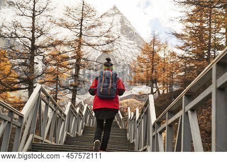 Rear View Of An Asian Woman Female Tourist Backpacker Climbing Up Stairs Leading To Mount Chenrezig 