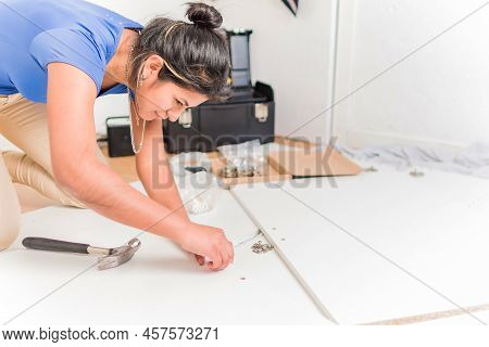 Latin Bolivian Strong And Independent Success Woman Assembly And Repair Furniture With Hammer.