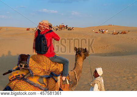 Thar Desert,rajasthan,india-15th October 2019 : Cameleer Looking Up To Female Tourist Photographing 
