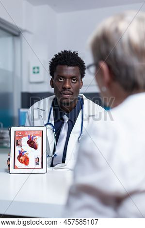 Cardiology Doctor Presenting Heart Problem And Disease Diagnostic To Elderly Cardiac Patient. Senior
