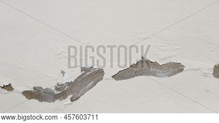 White Old Wall With Cracks, Grungy Cracked White Wall Paint Peeling Off. Caused By Being Damaged Wat