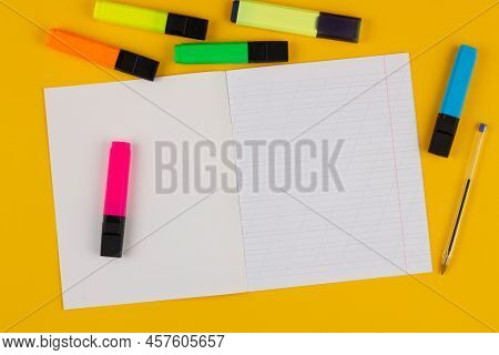 School Notebook On A Yellow Background With Copy Space For Text, Colorful Markers, English Alphabet.