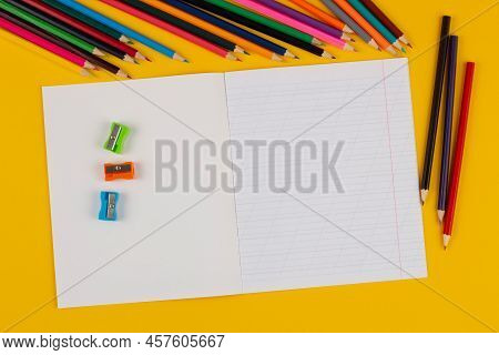 School Notebook On A Yellow Background With Copy Space For Text, Colorful Markers, English Alphabet.