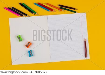 School Notebook On A Yellow Background With Copy Space For Text, Colorful Markers, English Alphabet.