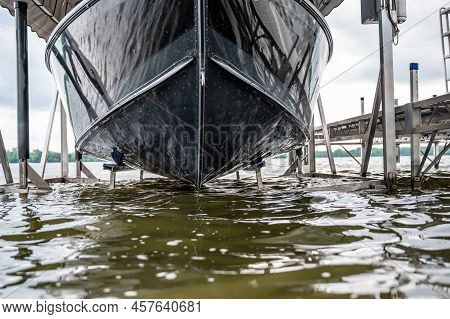 Boat With A Hydraulic Dock Lift Sitting Above The Water Line On A Lake.