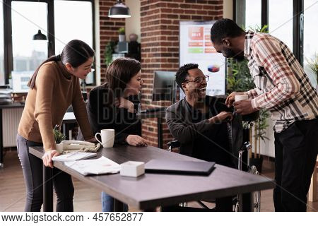 African American Man With Physical Impairment Having Fun At Work, Taking Break With Workmates. Male 