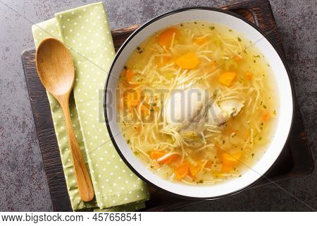 Delicious Homemade Chicken Broth With Noodles And Vegetables Close-up In A Plate On A Wooden Tray. H